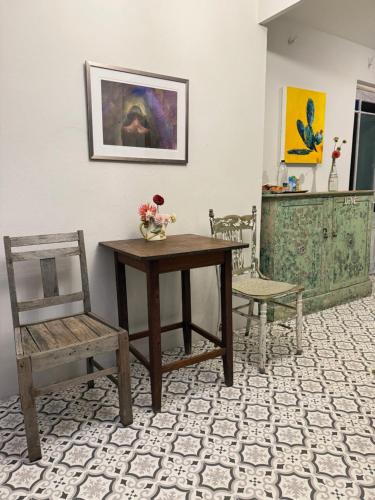 a table with a chair and a vase of flowers on it at French Kisses in Greyton