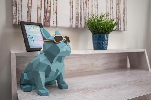 a dinosaur toy sitting on a desk with a laptop at Rocky Mountain Oasis-Mountain View! in Canmore