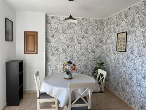 a dining room with a white table and chairs at "La Pinède" à l'ombre des pins tout simplement in Montfrin