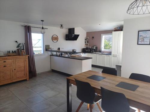 une cuisine et une salle à manger avec une table et des chaises dans l'établissement Maison Le Colety, à Locmaria