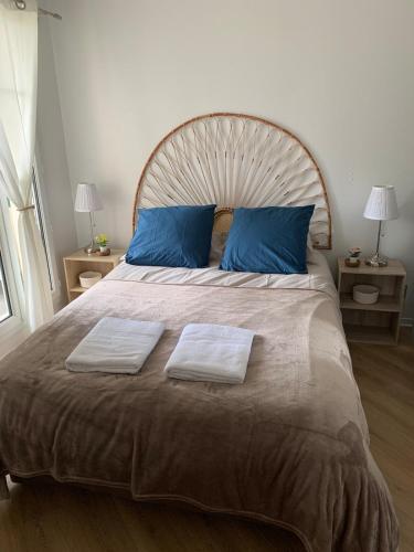 une chambre avec un grand lit avec deux serviettes dessus dans l'établissement Appartement 3 personnes Cabourg-Port Guillaume, à Dives-sur-Mer