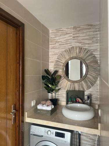 a bathroom with a sink and a mirror at Stunning Modern Apartment in heart of Agadir for families in Agadir