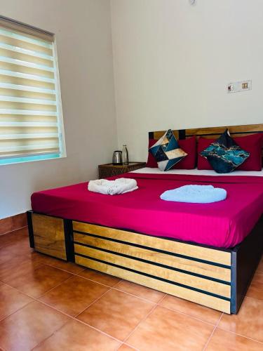 a large bed in a room with a red mattress at AquaTerra Comfy stay Varkala beach in Varkala