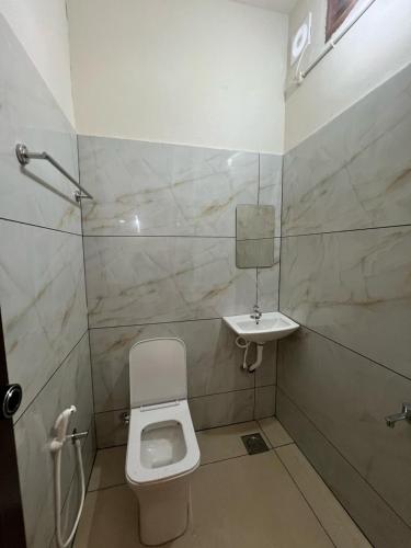 a bathroom with a toilet and a sink at AquaTerra Comfy stay Varkala beach in Varkala