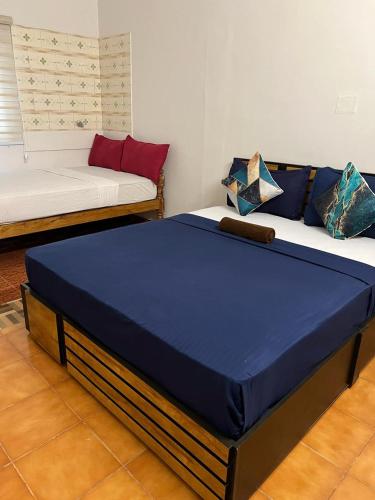a large bed in a room with a couch at AquaTerra Comfy stay Varkala beach in Varkala