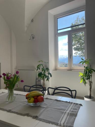 a table with a bowl of fruit and a window at La casa de lu Barone in San Demetrio neʼ Vestini