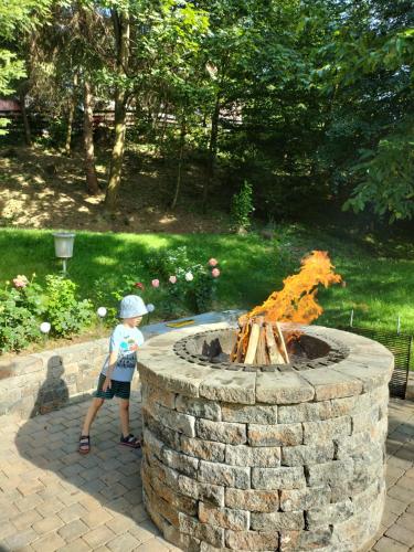 a young child standing next to a fire pit at Cabana Gura Voronețului in Gura Humorului