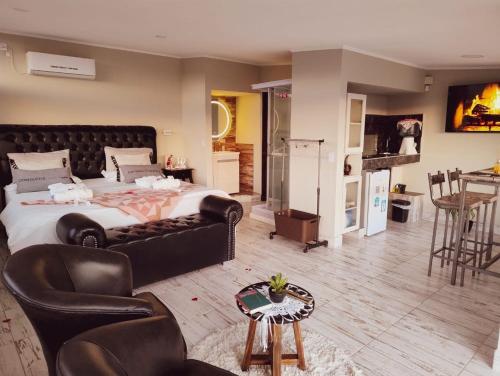 a bedroom with a large bed with leather furniture at AYRES SUITE in Villa Carlos Paz