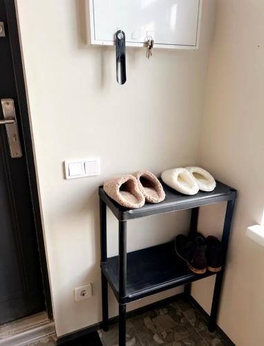 a bathroom with a shelf with two towels and shoes at City Center Apartment in Valga