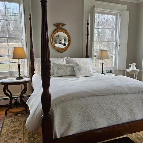 a bedroom with a large bed and two windows at Peach Grove House in Warwick