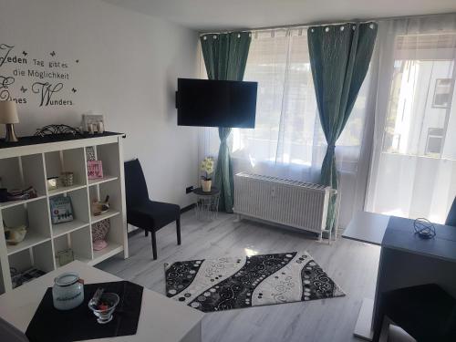 a living room with a tv and a chair and a table at Apartment Lieblingsplatz in Hameln