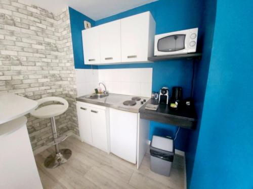 une petite cuisine avec un évier et un micro-ondes dans l'établissement 3 Rois - Joli studio 2 pers, place de parking, à Nantes