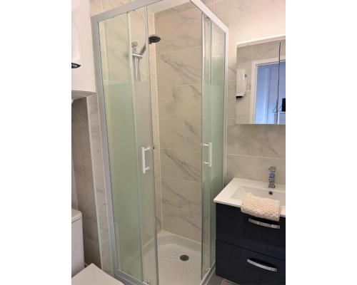une salle de bain avec une douche en verre avec un lavabo dans l'établissement La Sentinelle, à Leucate