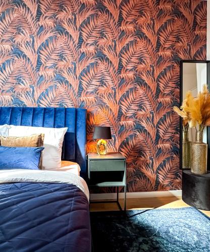 a bedroom with a blue bed and a wall mural at Cooth's Royale in Breda