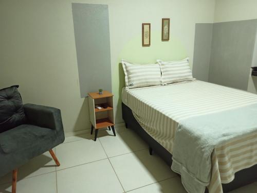 a small bedroom with a bed and a chair at NORTE HOTEL Guaraciaba in Inhussu