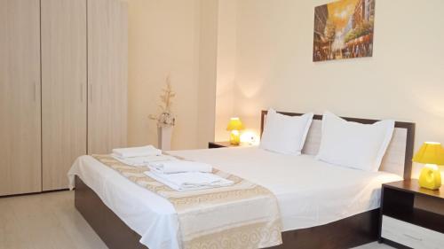 a bedroom with a bed with white sheets and pillows at Апартамент в непосредствена близост до плажа in Burgas City