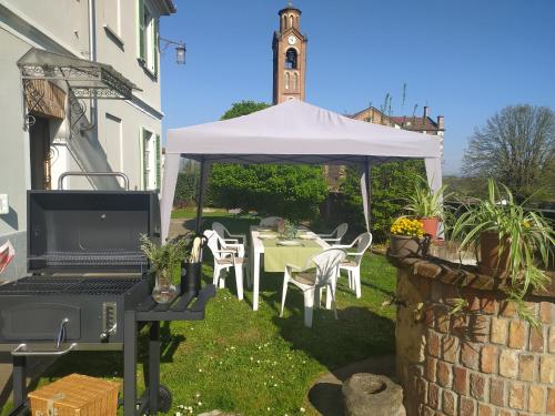 a table under a white tent with a clock tower at La casa nel Monferrato "LA CONTENTËSSA" in Asti