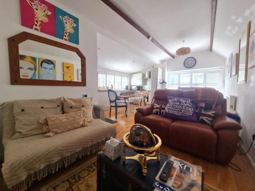 a living room with a couch and a table at Stylish Open Plan Guest House 400sq ft Rutland in South Witham