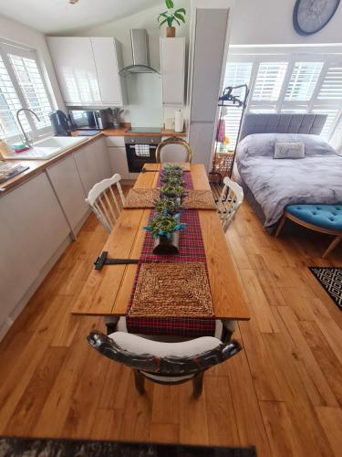 a kitchen with a wooden table in a room at Stylish Open Plan Guest House 400sq ft Rutland in South Witham