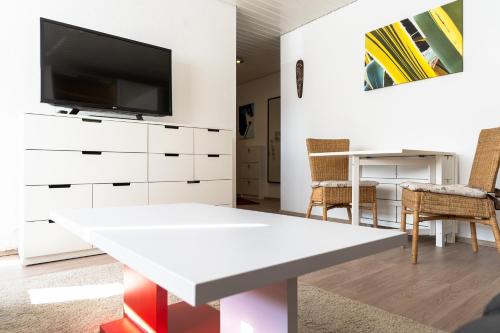 a living room with a tv on a white dresser at Exklusives Business Apartment in Lörrach