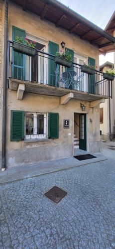 a building with green shutters and a balcony at Al Vicoletto Varese in Gazzada