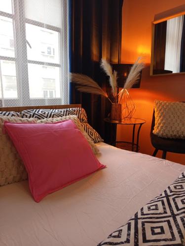 a bedroom with a large bed with a pink pillow at Rooms Center - dworzec PKP, rynek Wrocław in Wrocław