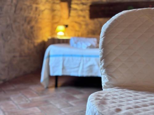 a room with a bed and a chair and a table at Hammam Rooms, Senorbì, Sardegna in Senorbì