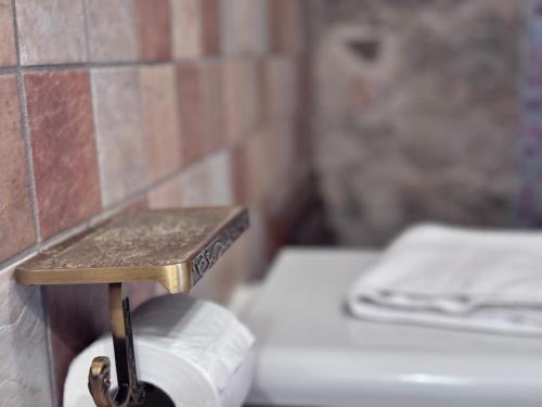 a toilet paper holder in a bathroom with a roll of toilet paper at Hammam Rooms, Senorbì, Sardegna in Senorbì