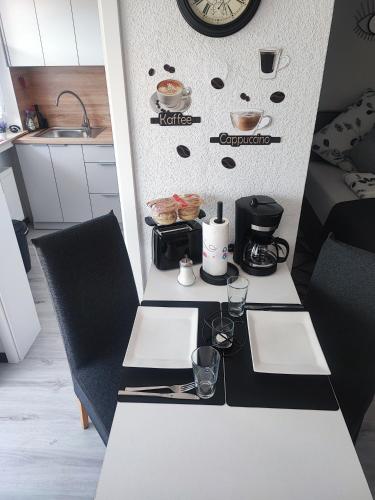 a kitchen with a table with two chairs and a clock at Apartment Lieblingsplatz in Hameln