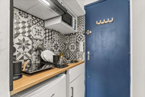 a kitchen with a blue door and a counter at Le Trésor Du Port- Plein Coeur du Vieux Port in Marseille