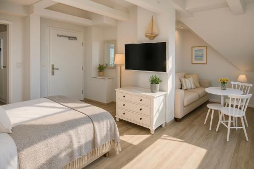 a bedroom with a bed and a tv and a couch at Lodge am Meer in Glücksburg