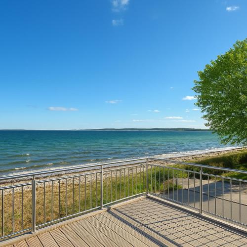 a walkway to the beach with the ocean in the background at Lodge am Meer in Glücksburg