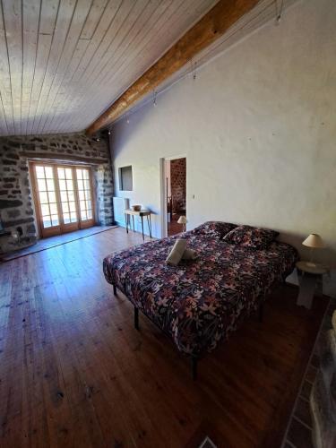 a bedroom with a bed and a wooden floor at La Maisonnette in Présailles