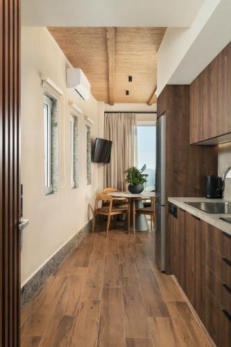a kitchen with wooden floors and a dining room with a table at Raviewha Luxury Apartments 2 in Ravdhoúkha