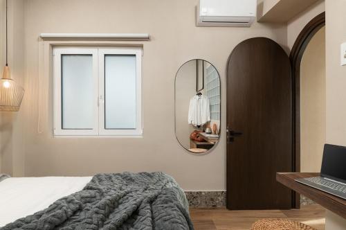 a bedroom with a bed and a mirror and a laptop at Raviewha Luxury Apartments 2 in Ravdhoúkha