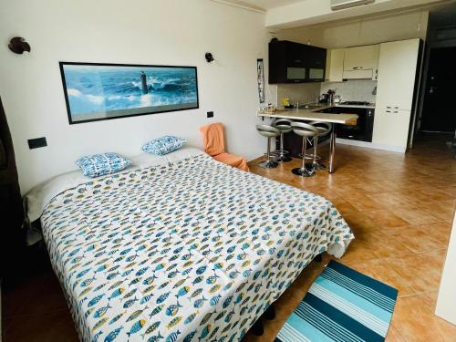 a bedroom with a bed and a kitchen with a sink at Piccola Navetta in Diano San Pietro