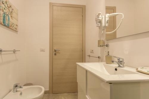a white bathroom with a sink and a toilet at Urban Beach Sirena in Francavilla al Mare