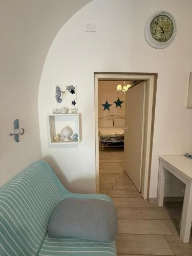 a living room with a blue couch and a table at Casetta Azzurra in Monopoli