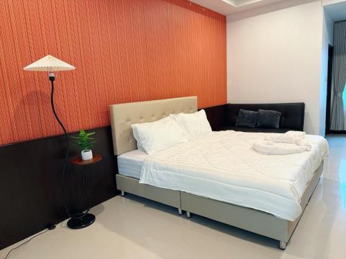 a bedroom with a bed with an orange wall at Green Haven Villas With Jacuzzi in Krabi town