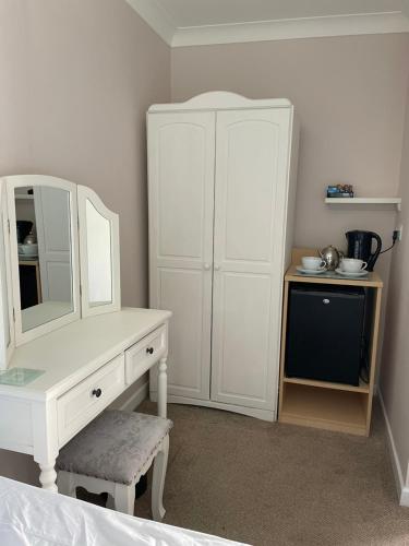 a bedroom with a white dresser and a mirror at The Eiders in Aylmerton