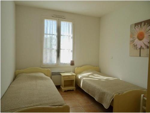 two beds in a room with a window at Sunset in Saint-Jean-de-Monts