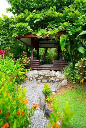 a garden with a smallilion in the middle of a yard at Sloth Premium Riverfront Jungle Villa with Jacuzzi and Pool in Uvita