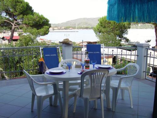a table and chairs on a balcony with a view of the water at Marina Azzurra VistaMare - HiTuscany in Marina di Campo
