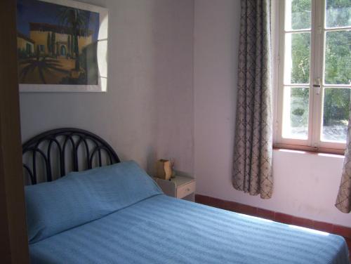 une chambre avec un lit bleu et une fenêtre dans l'établissement Location maison domaine viticole avec piscine, à Flassans-sur-Issole