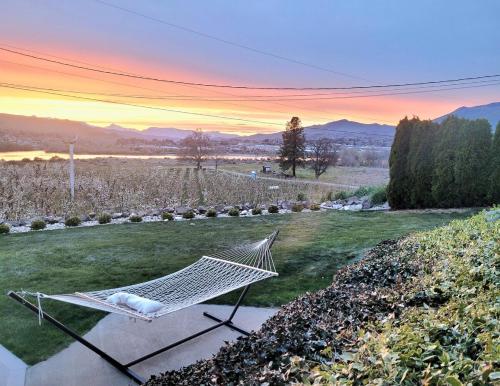 a hammock in a field of grass with a sunset at Immaculate Home w/ Mtn and River Views! in East Wenatchee