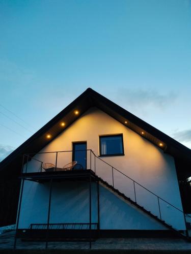 a house with a balcony and lights on it at Nad Stawami in Białowieża