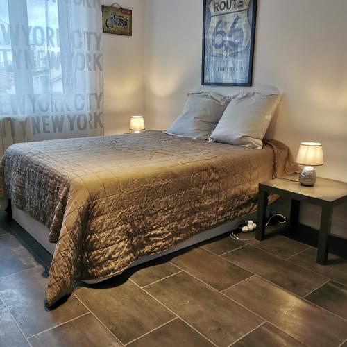 - une chambre avec un lit et 2 lampes sur une table dans l'établissement Maison 48m2 deux chambres cour privé et personnelle pour motos ou voitures 4 Pers proche mairie et bus tram, à Le Pont-de-Claix