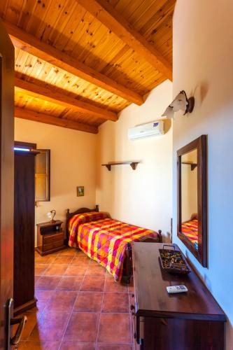 a bedroom with a bed and a desk in a room at Fattoria Terra e Libertà in Contrada Maeggio