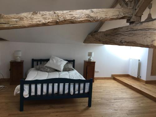 a bedroom with a bed and a wooden floor at Gite La Ferme En Sud Charente in Montboyer