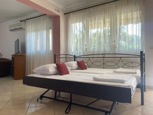 a bedroom with a large bed with white sheets and red pillows at House Garden in Kalamoti in Kalamoti